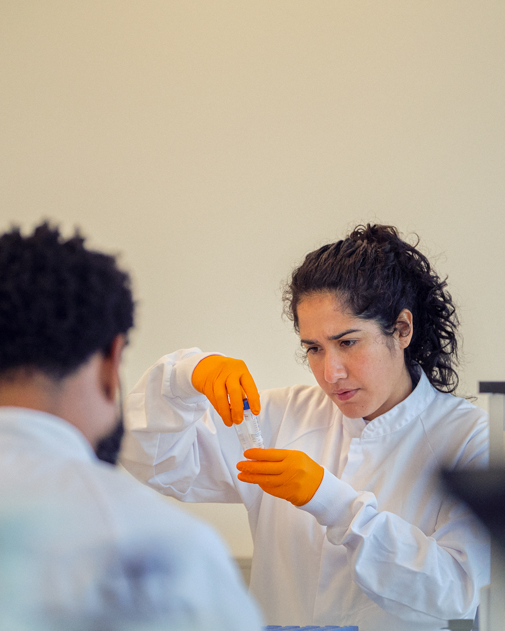 A professional scientist wearing a white lab coat, engaged in laboratory work